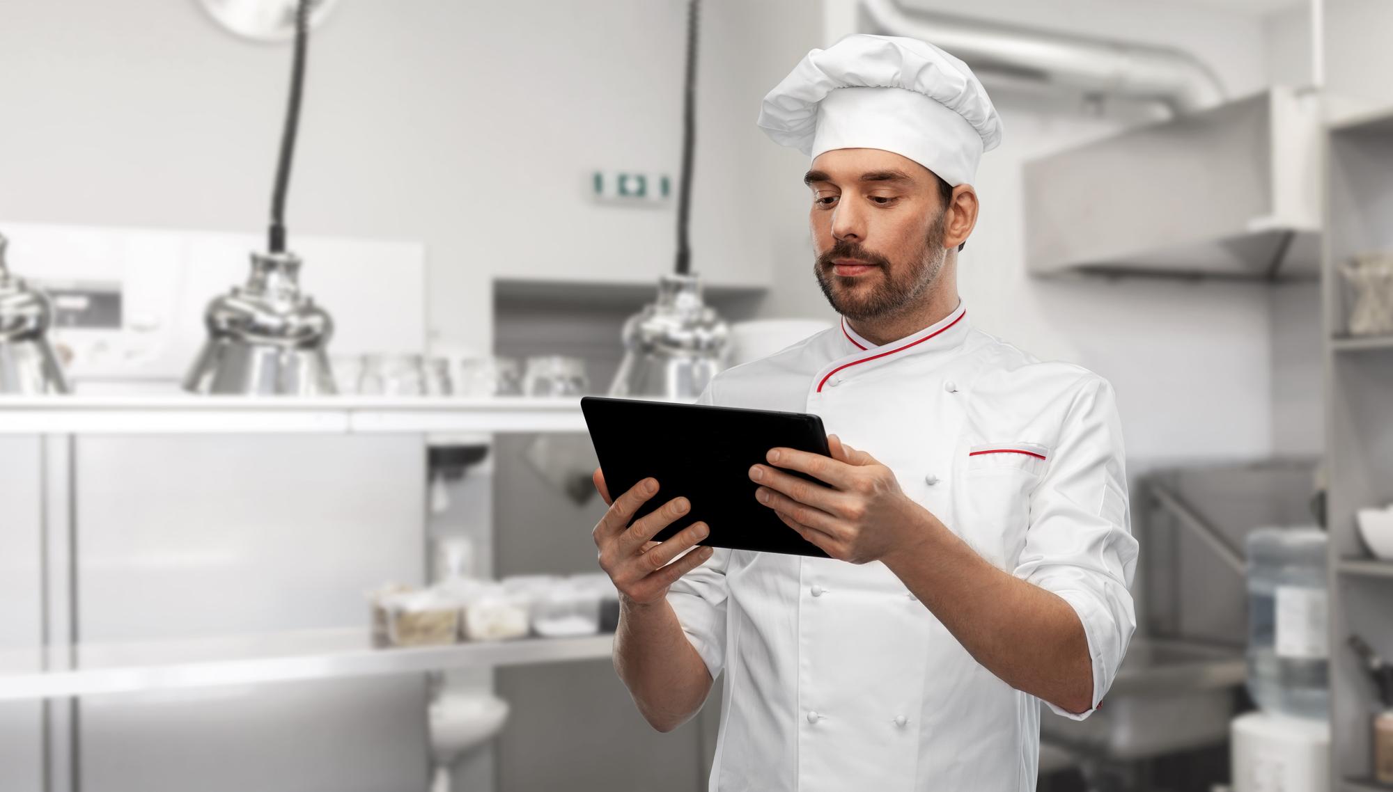 Szef kuchni z tabletem w nowoczesnej kuchni